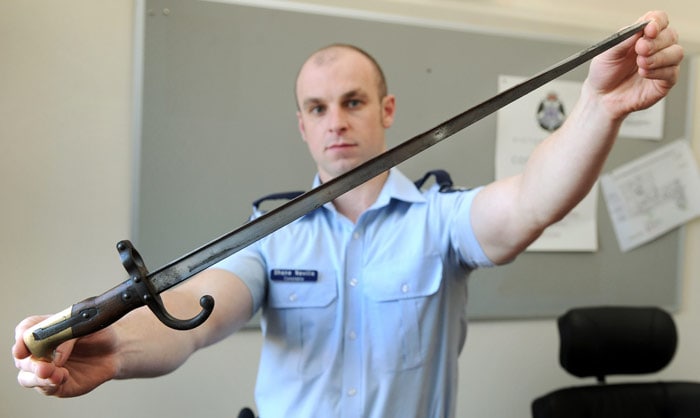 Australian policeman Shane Neville displays an inscribed old French bayonet after an elderly lady gave it to a police station as part of an arms amnesty, in Melbourne on July 6, 2010. The metre-long bayonet which has a wood and brass handle is inscribed with "Mme d'Oumer de Galle, Octobre, 1878", and is believed to have come from a 19th-century French-made Lebel rifle. Police called for more information on the bayonet and its inscription, with a local auction house deeming it worth many thousands of dollars. (Photo: AFP)