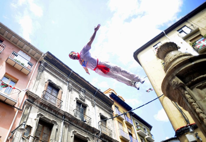 A man jumps from a fountain during the 'Chupinazo' to mark the start at noon sharp of the San Fermin Festival on July 6, 2010 in front of the Town Hall of Pamplona, northern Spain. The festival is a symbol of Spanish culture, despite heavy condemnation from animal rights groups, and attracts thousands of tourists to watch the bull runs.  (Photo: AFP)