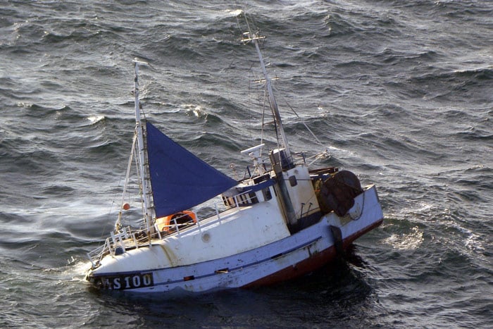 Handout phototaken by a Swedish SAR helicopter shows a Danish fishing boat with a heavy list after a collision off Grena, Denmark on July 6, 2010. The boat capsized just as the first crewmember was hoisted to safety and the remaining fisherman went under with the boat. A rescue diver managed to reach him and both the distressed men were brought to safety. (Photo: AFP)