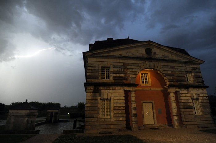 A picture shows on July 10, 2010 a building belonging to the Saline Royale site at Arc-et-Senans, eastern France as a flash is seen in the sky during the 9th edition of the "Nuit Bleue" event. The "Nuit Bleue" (Blue night) festival mixes electronic music, lighting effects and strolls in a UNESCO world heritage site. (Photo: AFP)