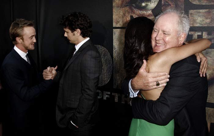 John Lithgow gives Freida a big hug, as Tom Felton and James Franco exchange notes.