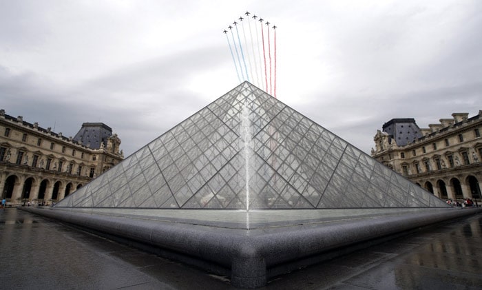 Alphajets from the French Air Force' Patrouille de France, or French Acrobatic Patrol, fly above the Louvre pyramid in Paris, on Wednesday July 14, 2010, as part of the traditional Bastille Day parade. (Photo: AP)