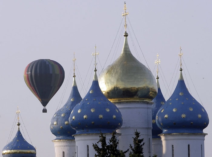 A Russian hot air balloon flies over the golden crosses of the Trinity-Saint Sergius monastery, 70 kilometres outside Moscow, in Sergiyev Posad on July 16, 2010. (Photo: AFP)