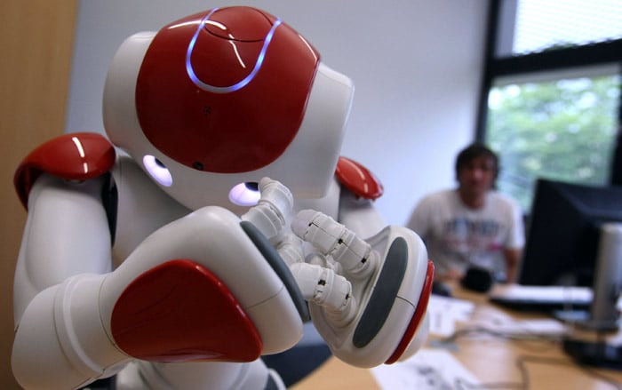 A student of the University Augsburg controls a Japanese android robot showing emotions on July 15, 2010 in Augsburg, southern Germany. The presentation was part of the open day programme of the university celebrating its 40th anniversary in 2010. (Photo: AFP)