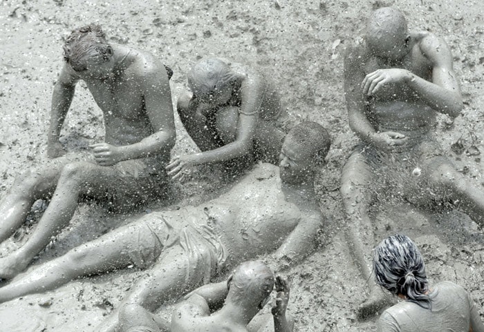 Tourists play in the mud during the 13th Boryeong Mud Festival at the Daecheon swimming beach in Boryeong, 190 kilometers southwest of Seoul on July 18, 2010. The annual festival encourages the use of mud for its benifits for skin-care and to promote tourism in the region. The festival runs from July 17-25. (Photo: AFP)