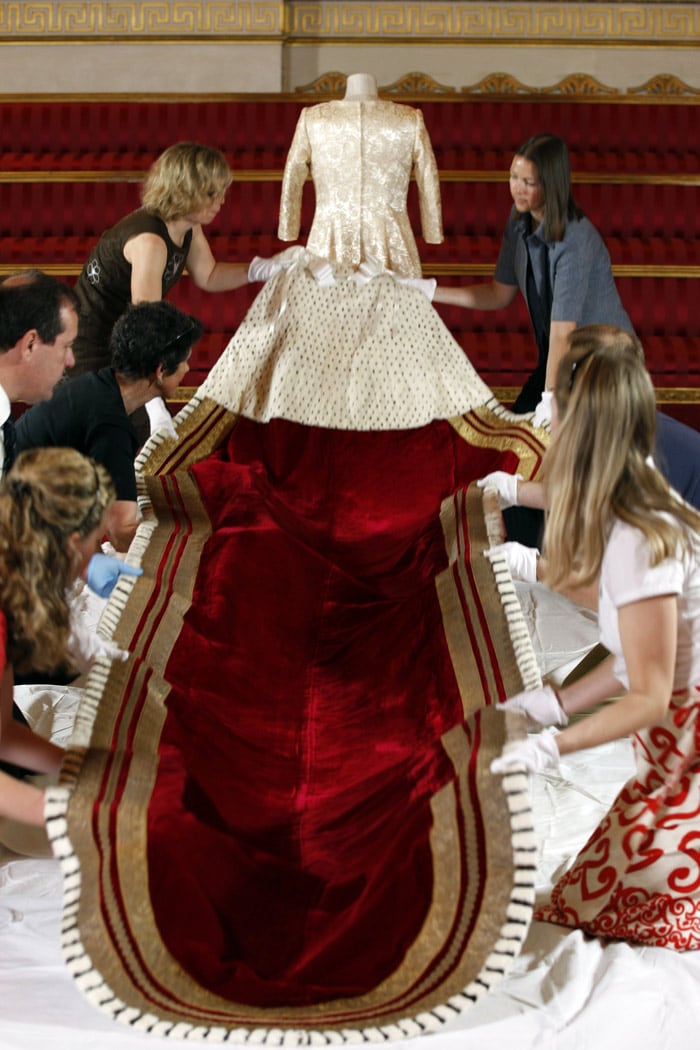 Members of staff prepare for public display, the Robe of State used by Britain's Queen Elizabeth II, for exhibition at Buckingham Palace in London Wednesday, July 14, 2010. The crimson velvet Robe of State was made for the Coronation of Queen Elizabeth II in 1953, weighs 7kg and measures over 18 feet long with an ermine cape and a long rich crimson velvet train fully lined with ermine and decorated with gold lace. The Robe of State is worn by the Queen at the State Opening of Parliament, and is being prepared for a special exhibition during the Summer Opening of Buckingham Palace, when the general public will be able to tour some of the rooms and galleries of the palace. (Photo: AP)