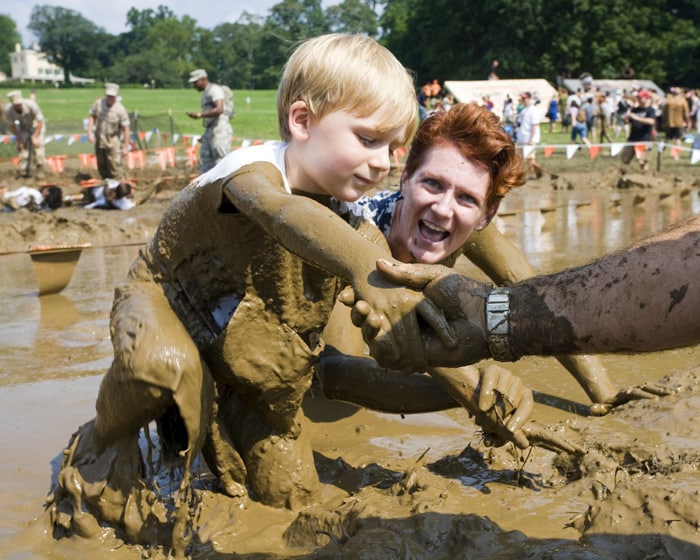 A child competitor is lent a hand from a military soldier and words from his mother while running through a mud pit which was the consistency of hot melted chocolate on their way to the finish line at the Merrell Down and Dirty National Mud Run Series on Sunday, July 18, 2010 in the urban Fairmount Park - Belmont Plateau, Philadelphia, Pa. A total of 4,500 competitors took part in the fun run series with a 10 K, 5 K, one mile and a 50 yard dash for the children. (Photo: AP)