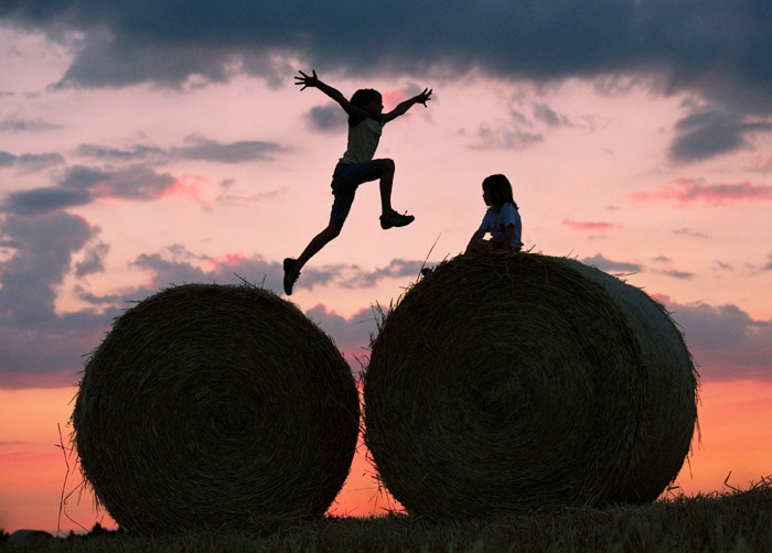 Two children play on bales of straw on a field in Petersdorf, eastern Germany, where the sun sets behind a red-colored sky on July 15, 2010. The country still experiences a heat-wave, with temperatures reaching 30 degrees Celsius and more. (Photo: AFP)