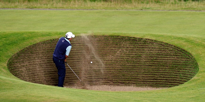 US golfer Ben Curtis takes two attempts to escape the road hole bunker during his opening round on the first day of the British Open Golf Championship at St Andrews in Scotland, on July 15, 2010. (Photo: AFP)