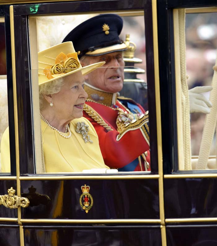 Her single crepe wool primrose dress is detailed with decorative beading at the neck. <br>In this picture,  Queen Elizabeth and Prince Philip sit in their carriage outside Westminster Abbey, just  after the Royal Wedding.