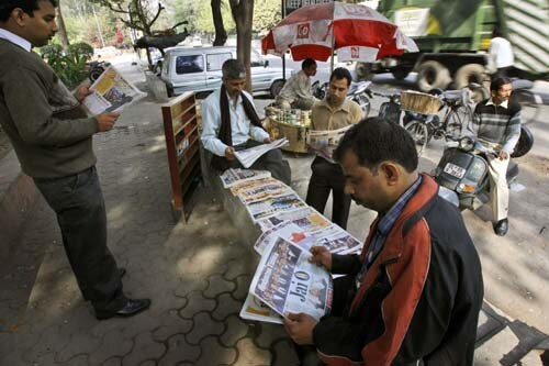 People reading headlines of Rahman's Oscar success with intent.