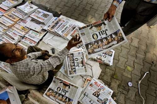 A newspaper vendor selling newspapers celebrating A R Rahman's success.