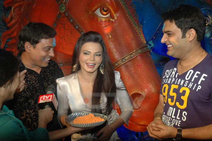 Rajiv Nigam, Rakhi and Kapil Sharma can't stop giggling as the colours are brought to her.