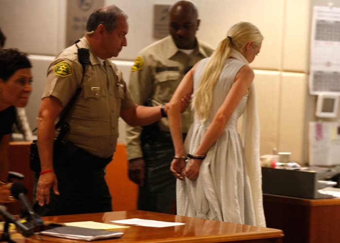 A handcuffed Lindsay Lohan exits the courtroom, her probation newly revoked. Lindsay's bail was set for $100,000.<br><br/>

More images: George Clooney and his new girlfriend