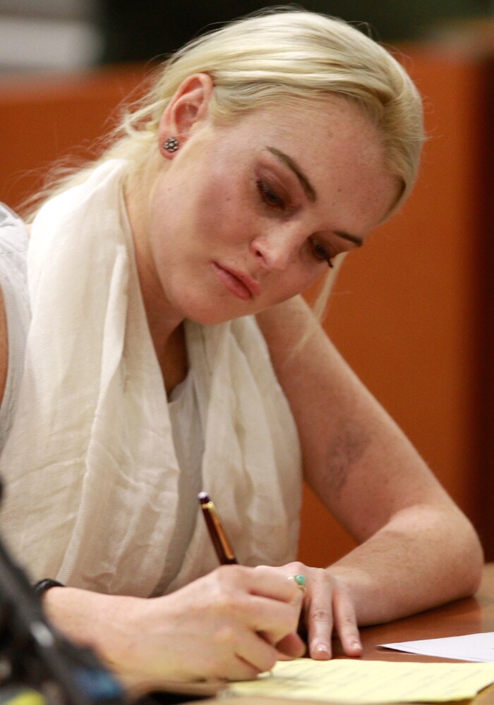 Actress Lindsay Lohan takes notes at her progress hearing at the Airport Branch Courthouse in Los Angeles.