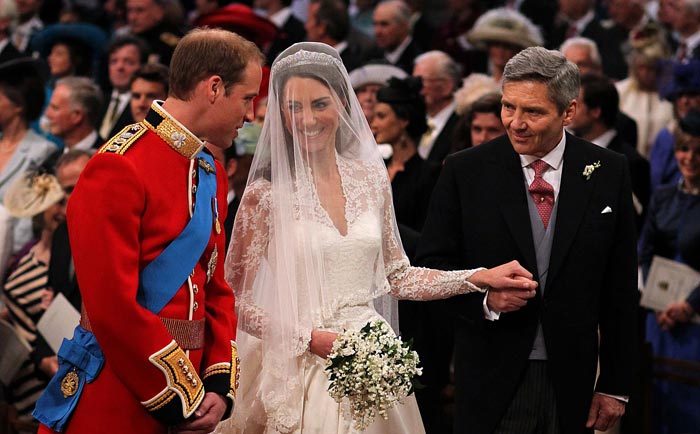 Kate and William share a moment as her father walks her down the aisle to her Prince