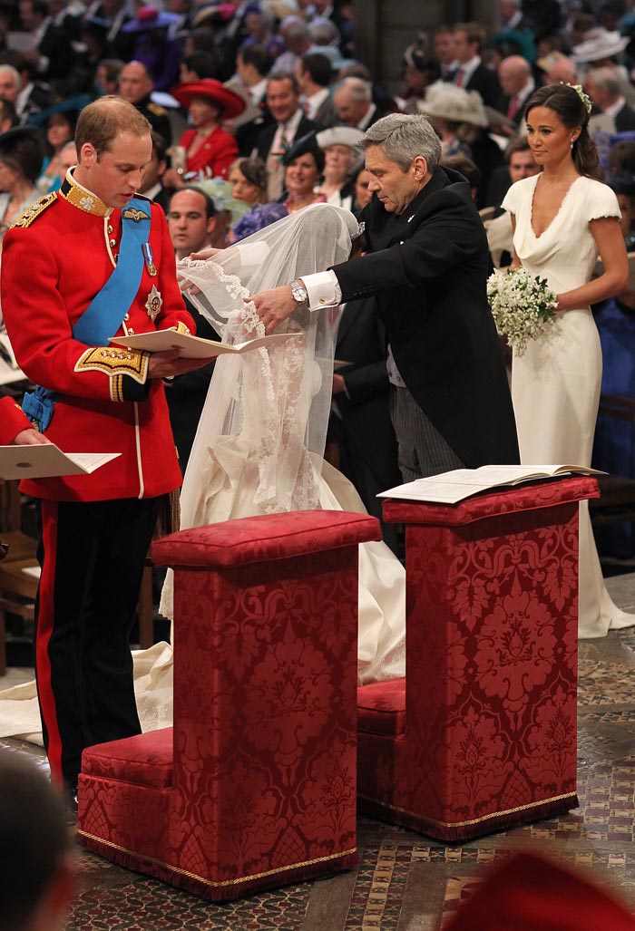 Kate's father, Michael Middleton, lifts her veil while sister Pippa looks on