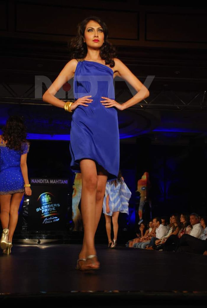 A model walks the ramp in a blue dress.