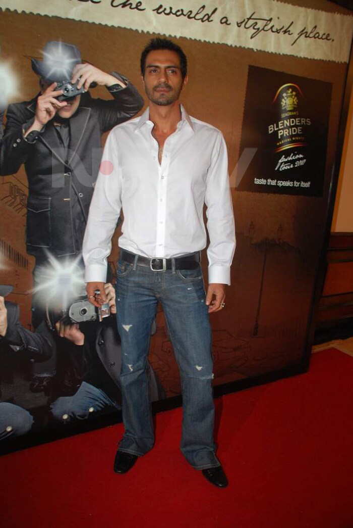 Arjun Rampal poses in front of the Blender's Pride poster.