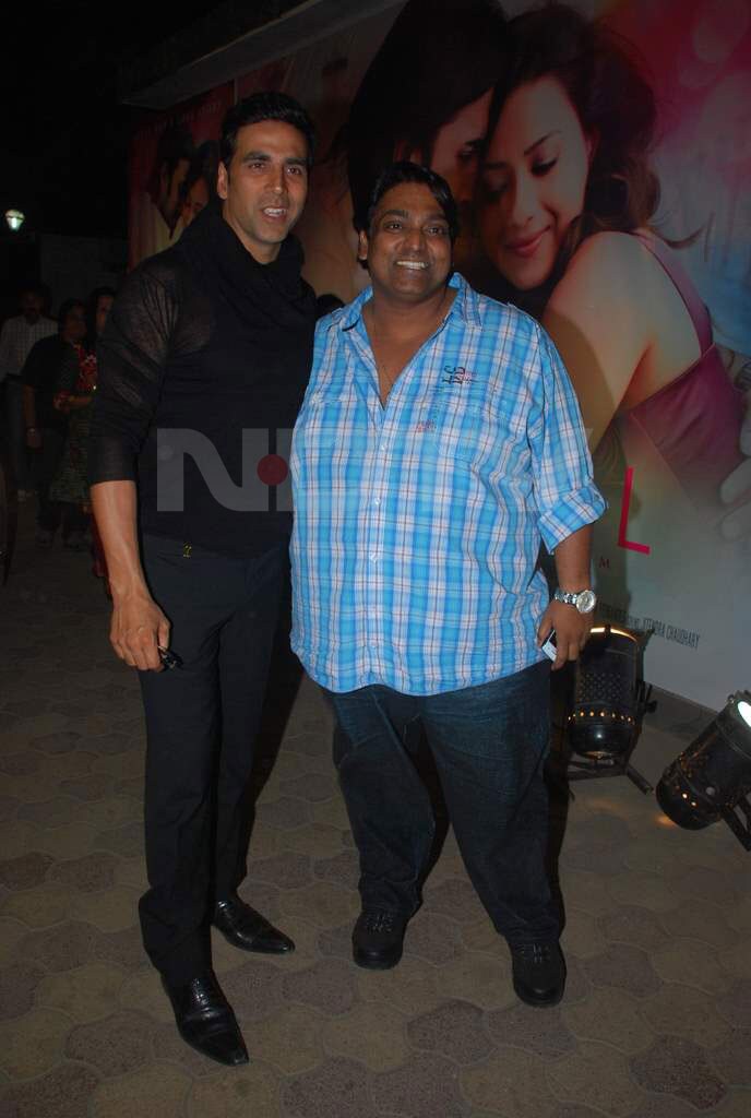 Akshay went about showing skin in a sheer black shirt at Angel's music launch. Top, posing with the director.