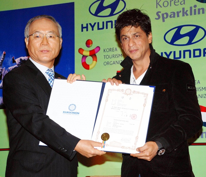 Shah Rukh Khan receives a certificate for his honourary black belt title in taekwondo from Kim Sik during an event held by the Korean National Tourism Organisation in Mumbai on October 15, 2009. "I have developed a keener interest in sports such as 'Taekwondo' now, as my son Aryan has won ten gold medals and daughter Suhana has won three gold medals in sports activities in their school," the actor was quoted as telling mediapersons present at the conference. (Photo: AFP, Text: Agencies)