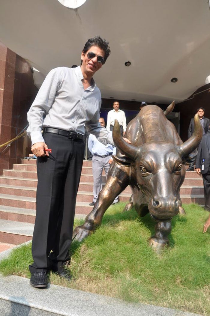 Shah Rukh with the bronze statue of a bull.