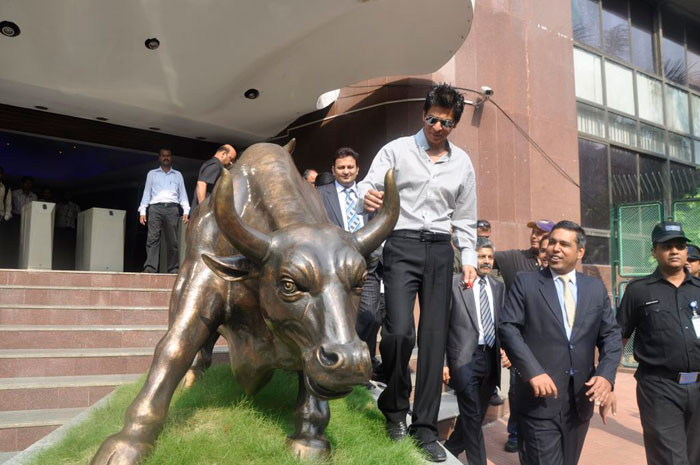 Shah Rukh looks at the bronze statue of a bull outside the Bombay Stock Exchange.