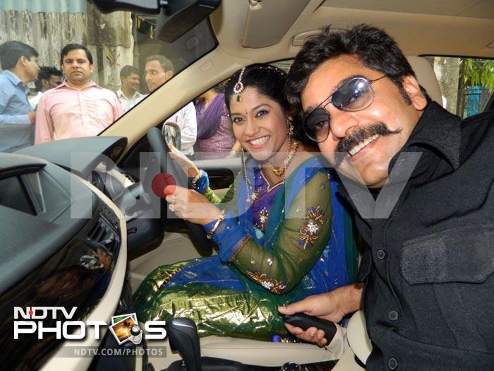 The lovely couple pose for the media in their new car.