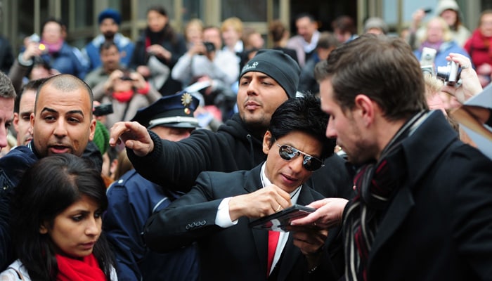 SRK signing autographs.