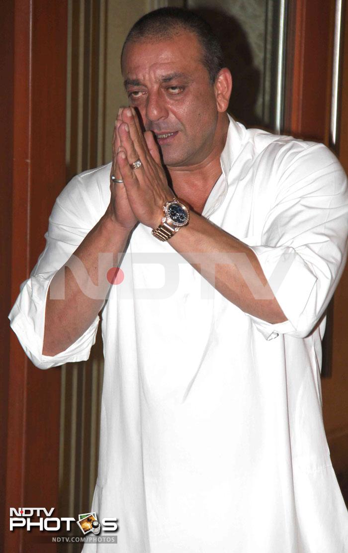 Sanjay Dutt greets the people gathered outside his house.