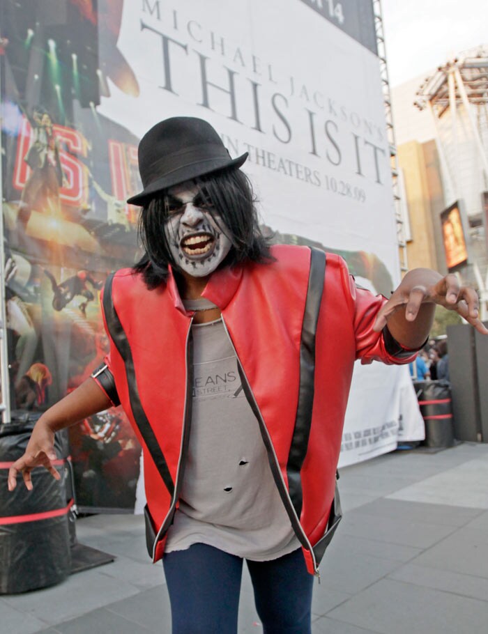 Emeral Smith, 20, of Palmdale, Calif., turned out as a ghoulish Michael Jackson, strikes a pose in front of a poster advertising the opening of the Jackson documentary, &quot;This Is It,&quot; after several hundred costumed dancers, hoping to set a worldwide record for the most people dancing simultaneously to the Jackson hit, &quot;Thriller,&quot; performed at LA Live, across from Staples Center in downtown Los Angeles. Thousands of dancers in some 400 cities worldwide were attempting to break the existing record of 16,000, event sponsors said. (Image: AP)