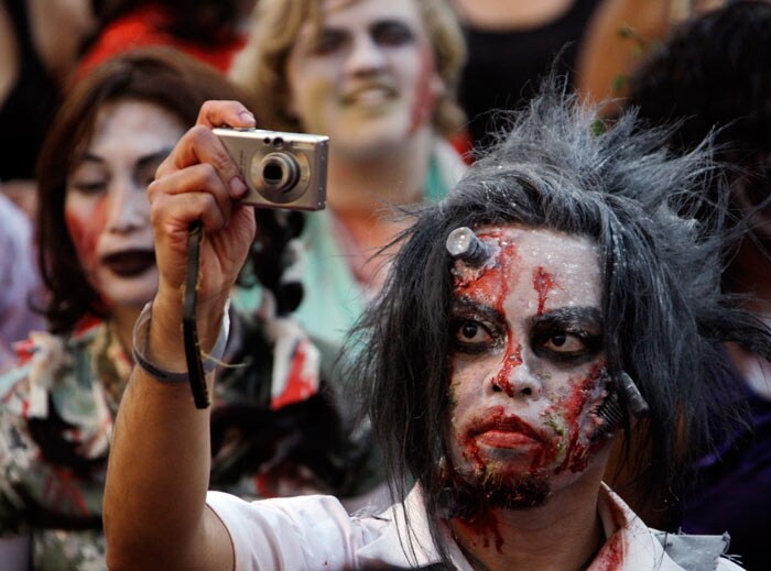 A costumed participant, among several hundred others, takes a photo while waiting to set a worldwide record for the most people dancing to the Michael Jackson hit, &quot;Thriller,&quot; at LA Live, across from Staples Center in downtown Los Angeles. (Image: AP)