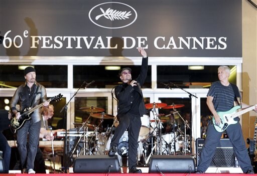U2 members, left to right, The Edge, Bono and Adam Clayton perform prior to screening of the film U2 3D, at the 60th International film festival in Cannes.