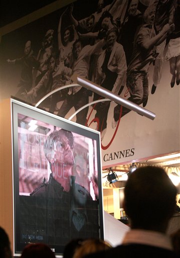 Onlookers watch as U2's Bono is reflected in a marquee while he performs for the screening of the film U2 3D, at the 60th International film festival in Cannes.