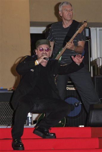 Irish musician Bono, left, and British musician Adam Clayton of the musical group U2 perform before the screening of the film U2 3D, at the 60th International film festival in Cannes.
