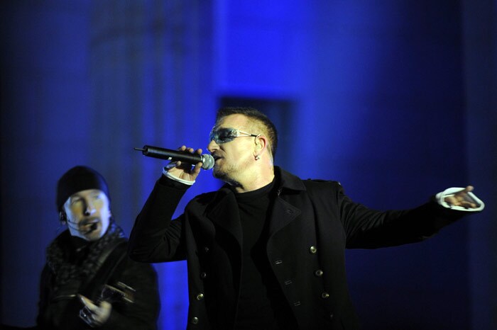 Bono (R), singer of the Irish rock band U2 performs on stage at the Brandenburg Gate in Berlin during a free open-air concert on November 5, 2009 as part of celebrations to mark the fall of the Berlin Wall 20 years ago. The concert will be aired live during the MTV European Music Awards also held in the German capital. (Photo: AFP)