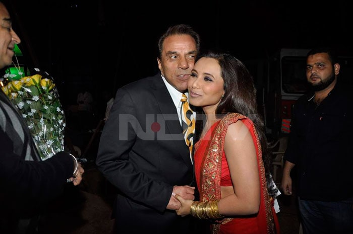 Rani Mukherjee and Dharmendra exchange an awkward looking cheek-to-cheek outside.