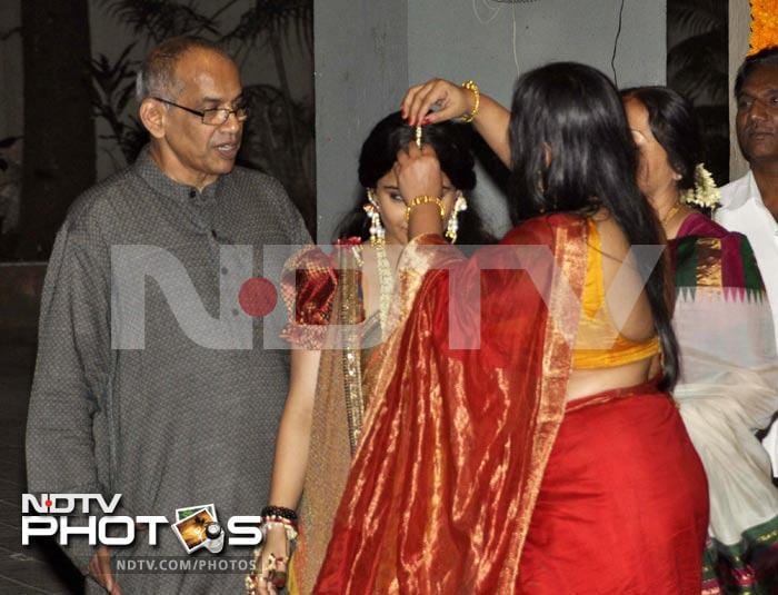 Elder sister Priya gets the <i>maang tika</i> in place as dad looks at his daughters.