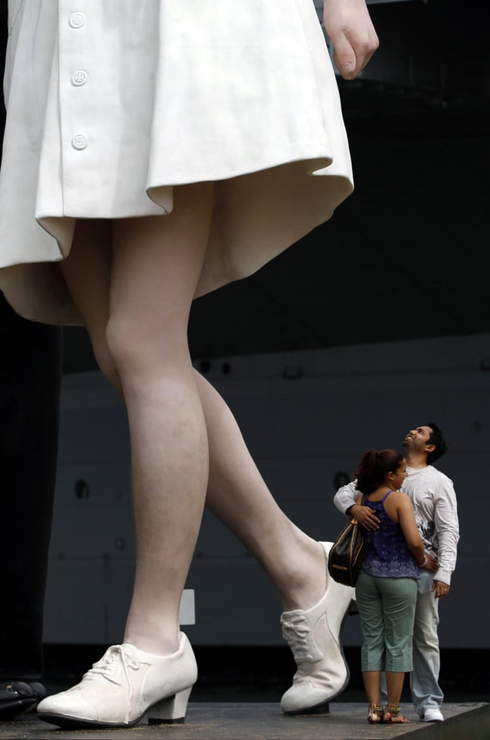 Imtiaz Zainule, right, of New York, looks up as he poses for a picture with Nicole Dhillon, of New York, under the sculpture 'Unconditional Surrender', on Friday, May 21, 2010 in San Diego. The sculpture, by J. Seward Johnson, commemorates the iconic image by photographer Alfred Eisenstaedt of a sailor kissing a nurse in Times Square on Aug. 14, 1945, during the celebration to mark V-J Day, the end of World War II. (Photo: AP)