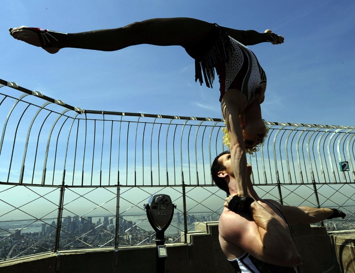 Acrobatic performers Preston Jamieson and Kelsey Wiens perform atop the the Empire State Building 86th floor observation deck on May 21, 2010 to promore the official opening night performance of the new Cirque du Soleil show 'Banana Shpeel'. The show will run until August 29 at the Beacon Theatre.  (Photo: AFP)