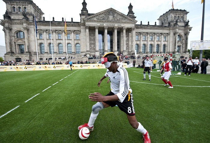 Football players wear blindfolds during a football match in front of the Reichstag, the building which houses the lower house of parliament, in Berlin on May 20, 2010. Turkish and German teams took part in the Blind football competition. (Photo: AFP)