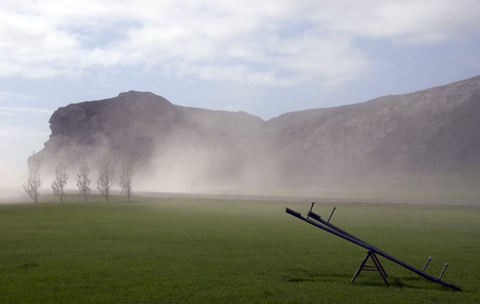 Grass is pictured as heavy clouds over dwellings set near the Eyjafjoell volcano in Iceland, on May 17, 2010. New ash clouds blasted out from Iceland's Eyjafjoell volcano brought fresh travel chaos to thousands of air travellers on May 17, 2010 as key European airports shut down. (Photo: AFP)