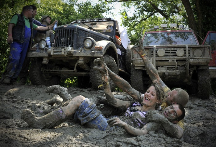 People wallow in the mud during the annual Somogybabod International Off Road Festival in Somogybabod, 165 km southwest of Budapest, Hungary, on Saturday, May 22, 2010. Environmentalists call to ban the annual off road event, saying that the hundreds of 4X4 vehicles destroy the forest area close to the Lake Balaton, Hungary's largest water and tourist resorts. (Photo: AP)