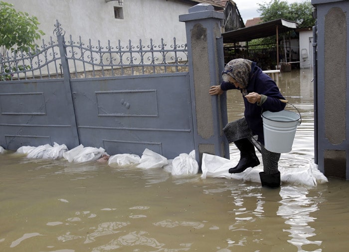 An elderly woman leaves her home to bring drinking water as she steps over some sandbags around her house in flood water of Szendro village, northeastern Hungary about 200 kms from Budapest on May 17, 2010. The area of north-eastern Hungary has declared as a disaster-hit territory. (Photo: AFP)