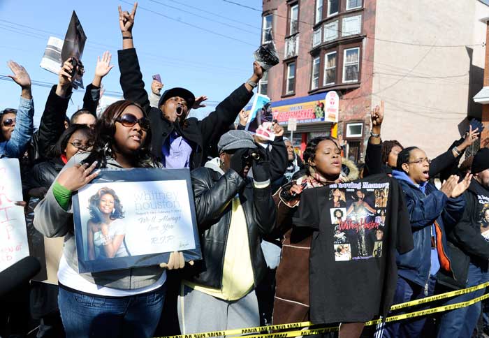 Fans sing near the funeral service for singer Whitney Houston at the New Hope Baptist Church in Newark, N.J., Saturday, Feb. 18, 2012.