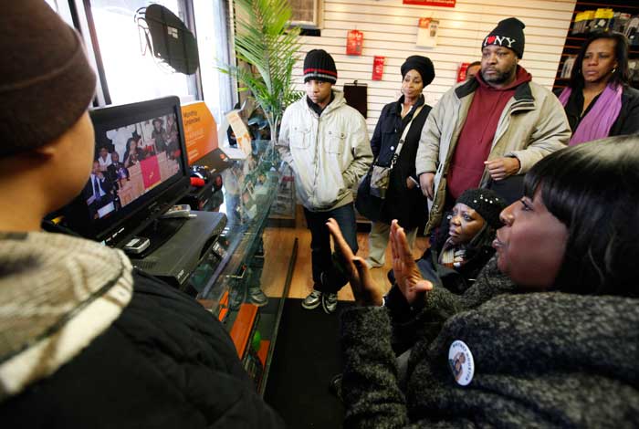 Whitney Houston fans gather around a television in a mobile phone store a few blocks from the New Hope Baptist Church to watch the singer's funeral.