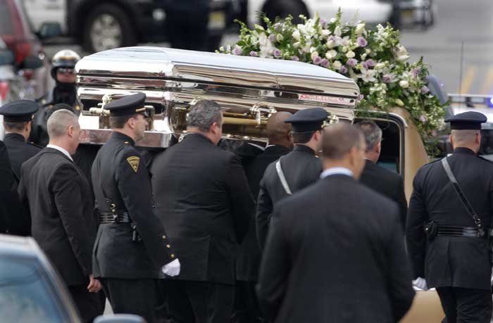 The coffin holding the remains of singer Whitney Houston is carried to a hearse after funeral services at the New Hope Baptist Church in Newark, N.J.