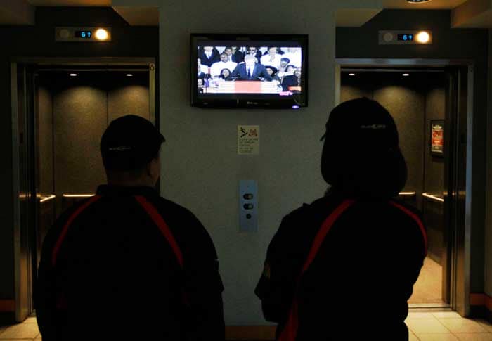 Concession workers at the United Center, watch actor Kevin Costner eulogize Whitney Houston before an NBA basketball game between the Chicago Bulls and the New Jersey Nets, Saturday, Feb. 18, 2012.