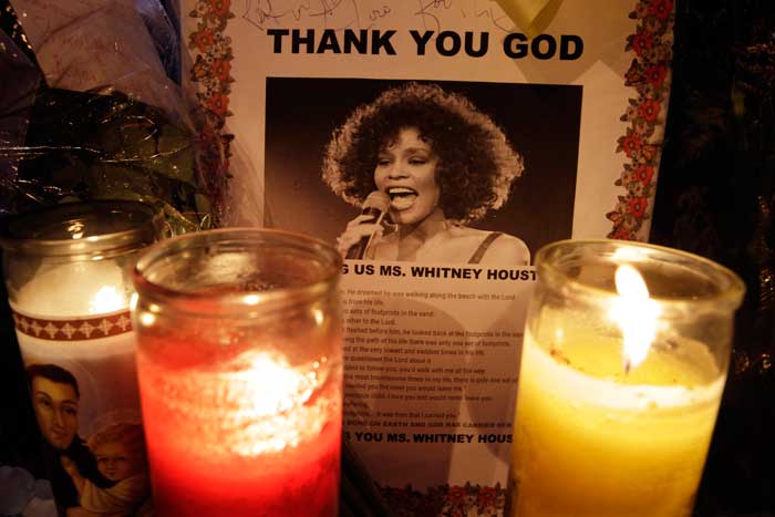 Whitney Houston, who ruled as pop music's queen until her majestic voice and regal image were ravaged by drug use, erratic behavior and a tumultuous marriage to singer Bobby Brown, was given a farewell by her close family and friends in a private ceremony.<br><br> Seen in the picture: Candles burn at a memorial to Whitney Houston outside New Hope Baptist Church in Newark, New Jersey.