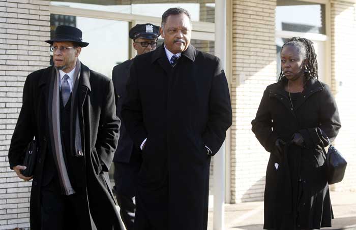 The Rev. Jesse Jackson, center, leaves Whigham Funeral Home after visiting with the family of Whitney Houston before going to the New Hope Baptist Church for her funeral in Newark, N.J.